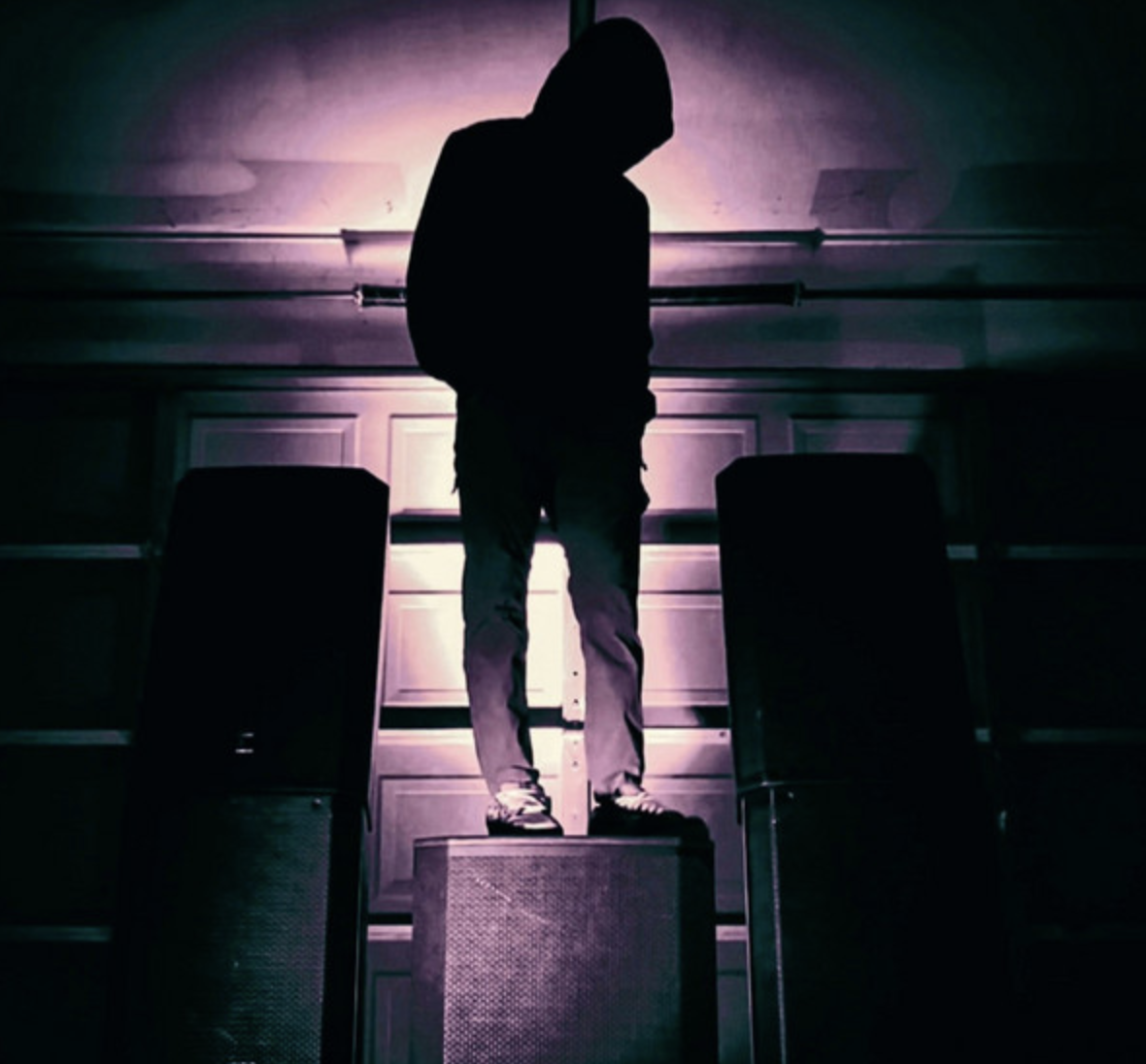 Between stage speakers under purple light